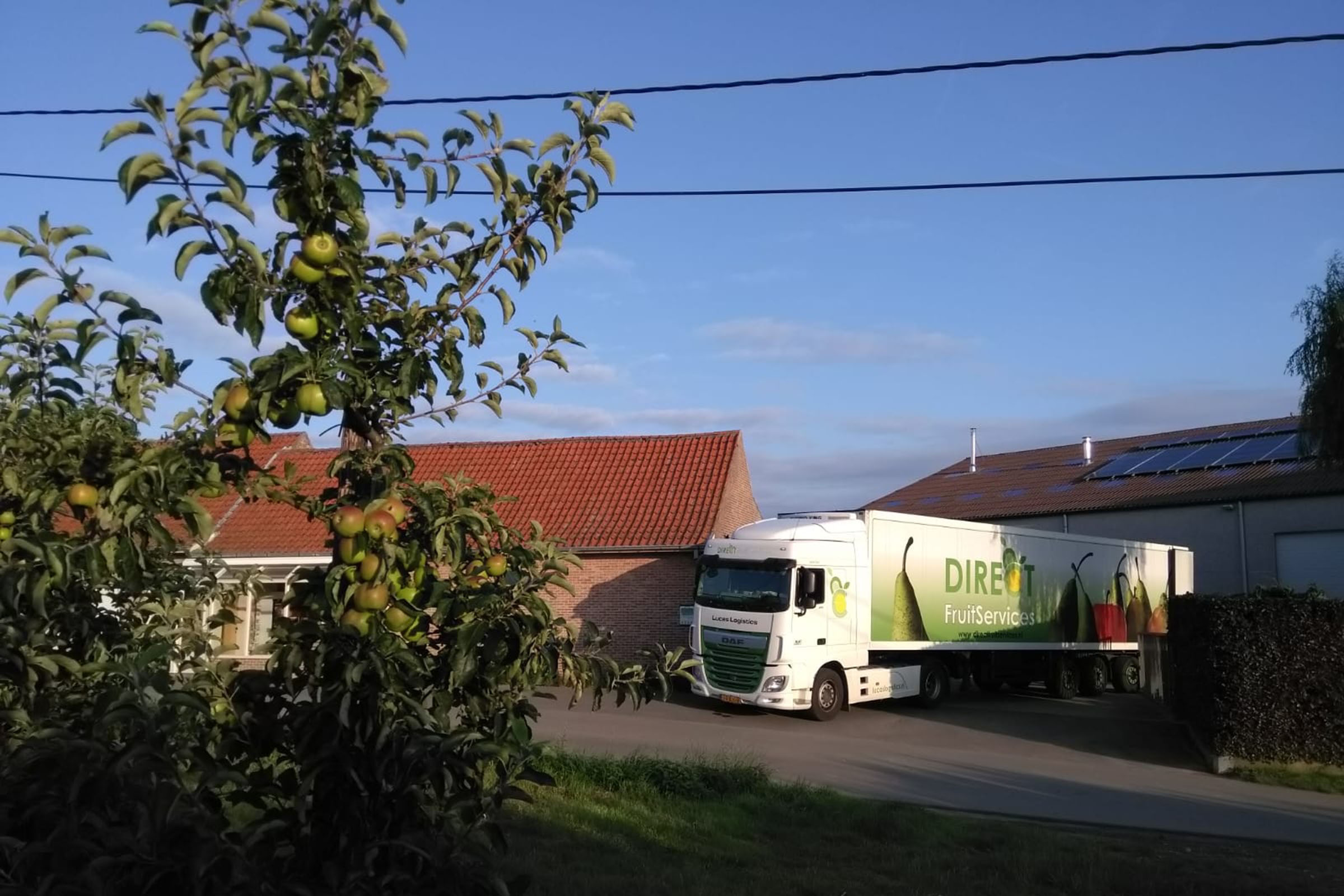 Vrachtwagen van Direct fruit service rijdt straat op.