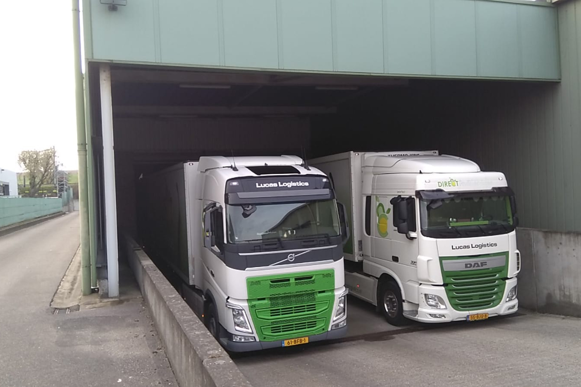 Twee vrachtwagens naast elkaar bij magazijn
